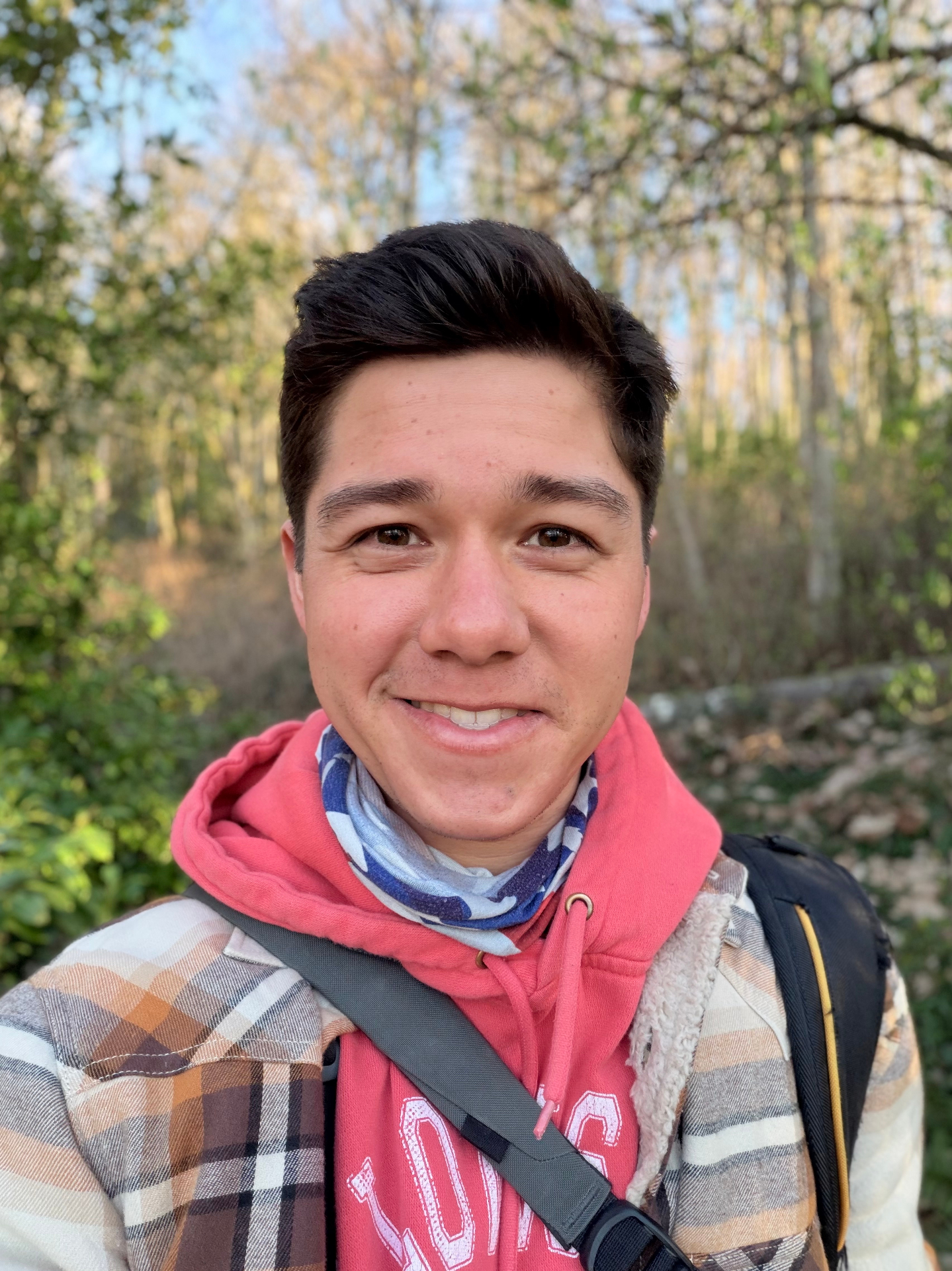 Author Josiah David Wilson smiling on a wooded hiking trail surrounded by lush trees